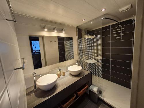 a bathroom with two sinks and a mirror at Le pas de la Fagne in Sprimont