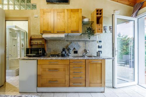 a kitchen with wooden cabinets and a sink at Le Dimore Apartments - Garden & Private Parking in Verona