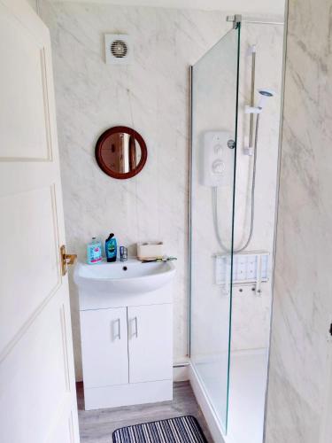 a bathroom with a sink and a glass shower at Sherlock's House --Melbourne 4 BR sleep 9 Privat parking x 3 vans Super WiFi Enclose rear garden Contractors Family with children Relocators Long stay Dogs welcome Close to Alton tower Twycross Zoo in Burton upon Trent