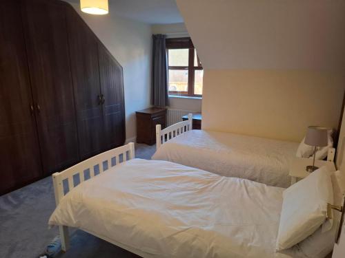 a bedroom with two beds and a window at Rostrevor Beach House in Rostrevor