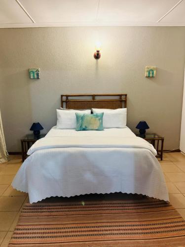 a bedroom with a large bed with white sheets and pillows at Apt 66 Eden Wilds Umtamvuna Getaway in Port Edward