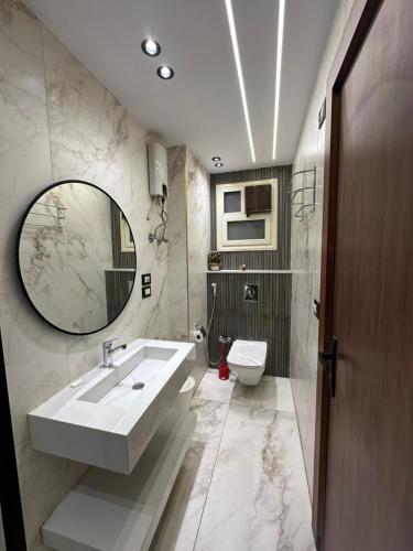 a bathroom with a sink and a toilet and a mirror at New City Plaza in Cairo
