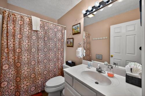 a bathroom with a sink and a toilet and a shower at Sunshine Cottage Hot Tub Game Room Grill MORE in Sevierville