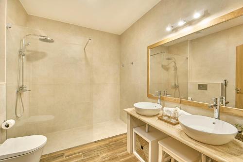 a bathroom with two sinks and a shower at Hotel Rural Quinta do Marco - Nature & Dining in Tavira