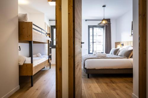 a bedroom with two beds and a hallway with two bunk beds at TERRESENS - Les Sources de Canopée in Saint-Gervais-les-Bains