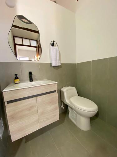 a bathroom with a toilet and a sink and a mirror at Apartamento VIP en Buga in Buga
