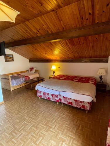 a bedroom with a large bed and a wooden ceiling at Chalet les Lurins in Villarlurin