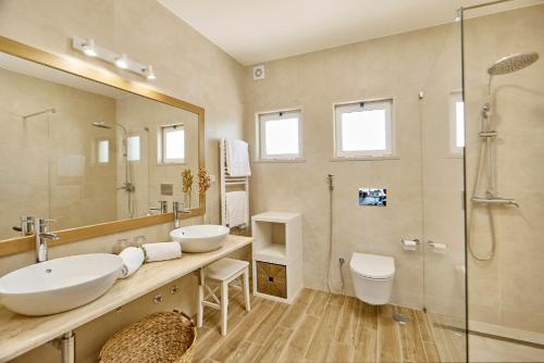 a bathroom with two sinks and a shower at Hotel Rural Quinta do Marco - Nature & Dining in Tavira