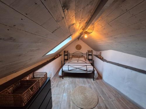 a small attic room with a bed and a light at Le pas de la Fagne in Sprimont