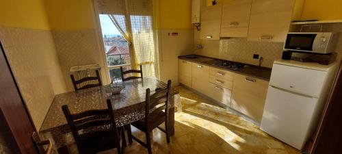 a kitchen with a table with chairs and a refrigerator at Appartamento PANORAMA N 4 POSTI LETTO in Varazze