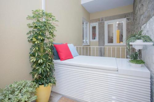 a white bench sitting on a balcony with plants at Liiiving in Porto - Clérigos Terrace Apartment in Porto