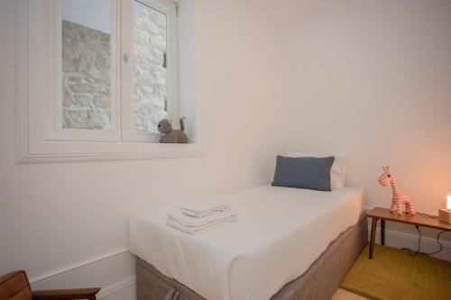 a bedroom with a white bed and a window at Liiiving in Porto - Clérigos Terrace Apartment in Porto