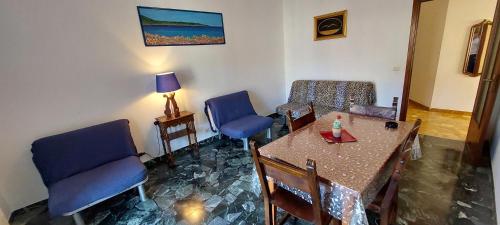 a dining room with a table and blue chairs at Appartamento PANORAMA N 4 POSTI LETTO in Varazze