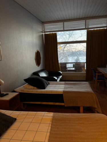 a bedroom with a large bed and a window at Hotelli Pihkuri in Viitasaari