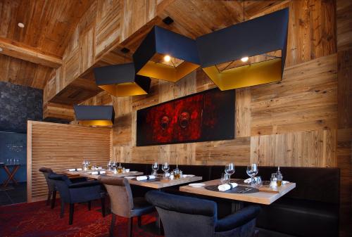 a restaurant with wooden walls and tables and chairs at Hôtel Koh-I Nor by Les Etincelles in Val Thorens