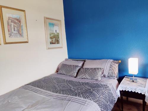 a bedroom with a bed and a blue wall at Sherlock's House --Melbourne 4 BR sleep 9 Privat parking x 3 vans Super WiFi Enclose rear garden Contractors Family with children Relocators Long stay Dogs welcome Close to Alton tower Twycross Zoo in Burton upon Trent