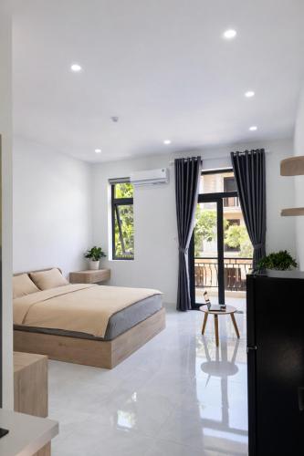a bedroom with a bed and a large window at The One Apartments in Tân Uyên