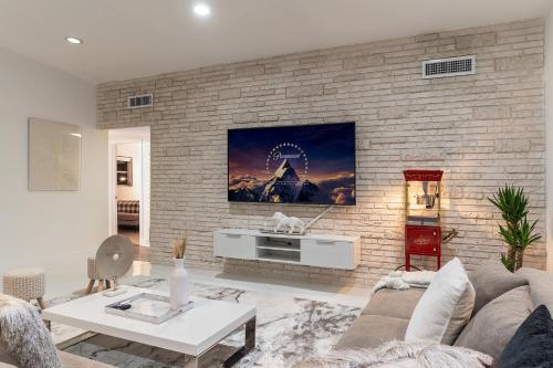 a living room with a couch and a tv on a brick wall at Miami Villa with Heated Pool Luxury Stay in North Miami Beach