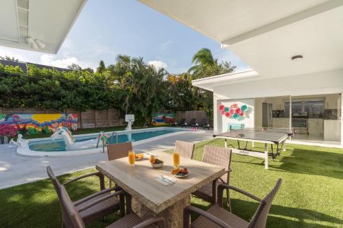 a backyard with a ping pong table and a pool at Miami Villa with Heated Pool Luxury Stay in North Miami Beach
