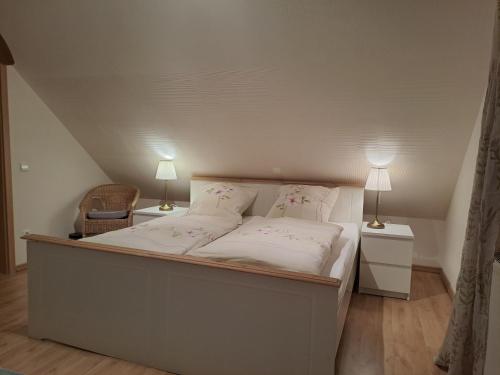 a bedroom with a bed with two lamps and a chair at Ferienhaus Bielefeld in Bielefeld
