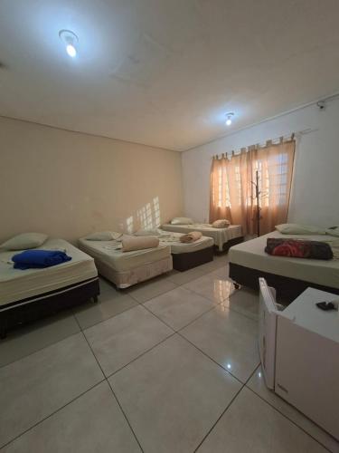 a room with four beds in it with lights at Hotel Padre Vitor in Aparecida
