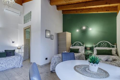a room with two beds and a table and chairs at Le Dimore Apartments - Garden & Private Parking in Verona