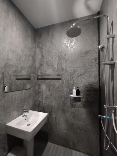 a bathroom with a sink and a shower at บ้านพักมิตรภาพโฮมสเตย์ in Ban Choko