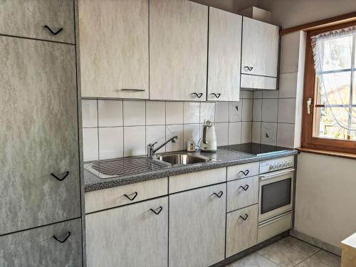 a kitchen with white cabinets and a sink at Apartment Diana by Interhome in Münster