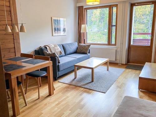 a living room with a blue couch and a table at Holiday Home Ylläs chalets a307 by Interhome in Ylläs