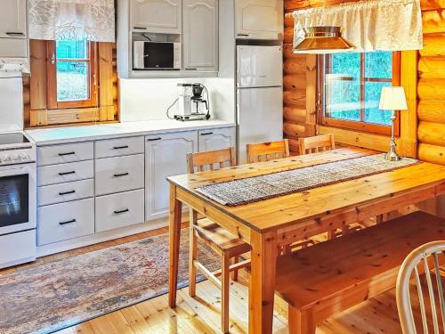 a kitchen with a wooden table in a cabin at Holiday Home Eskola by Interhome in Lahdenperä