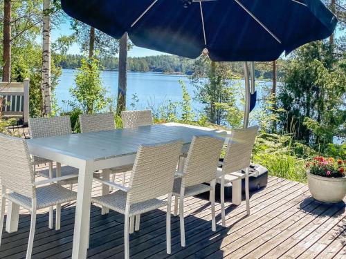 a table with chairs and an umbrella on a deck at Holiday Home Sointukallio by Interhome in Savonlinna