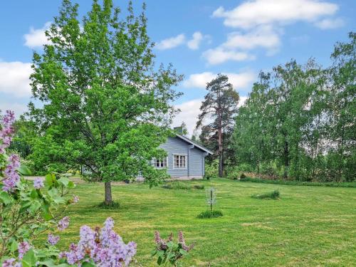 a house in the middle of a yard with a tree at Holiday Home Annas beach by Interhome in Haminankylä