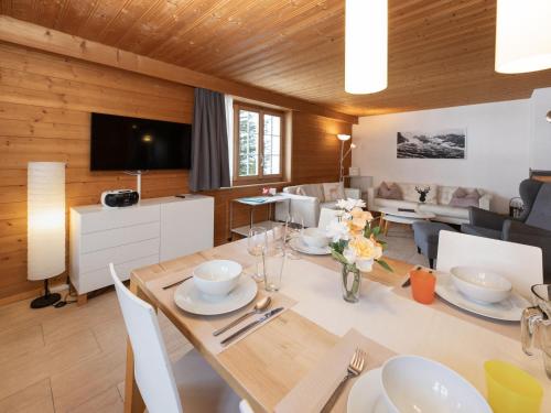 a dining room with a table and a living room at Holiday Home Chalet Reinhysi by Interhome in Grindelwald