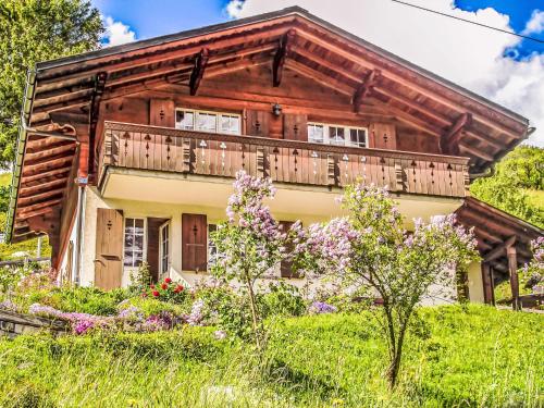 a house with a balcony on a hill with flowers at Holiday Home Chalet Reinhysi by Interhome in Grindelwald