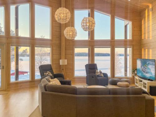 a living room with a couch and chairs and a tv at Holiday Home Leinola by Interhome in Sotkamo