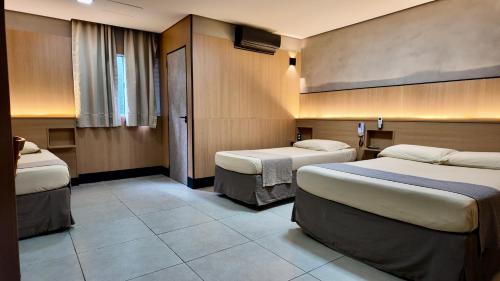 a hotel room with two beds in a room at Pousada Du Valle in Embu