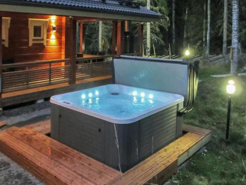 a jacuzzi tub with candles in front of a cabin at Holiday Home Villa utu by Interhome in Kolinkylä