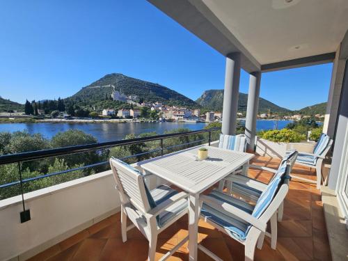 a table and chairs on a balcony with a view of the water at Apartment Waterfront Oasis-2 by Interhome in Mali Ston