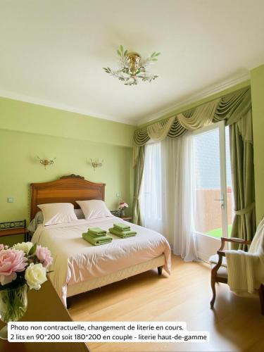 a bedroom with a bed and a large window at La Rose du Château in Lourdes