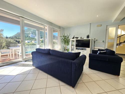 a living room with two blue couches and a television at Apartment Waterfront Oasis-1 by Interhome in Mali Ston