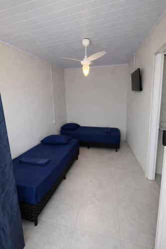 two beds in a room with a ceiling fan at Morá 2 Coliving in Cachoeirinha