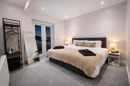 a bedroom with a large bed and a large window at The Fratton Apartment with parking in Portsmouth