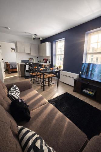 a living room with a couch and a large tv at Dwntwn Detroit Wlk to DMC Arena WSU FordField in Detroit
