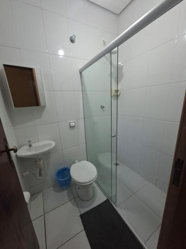 a bathroom with a shower and a toilet and a sink at Hotel Padre Vitor in Aparecida