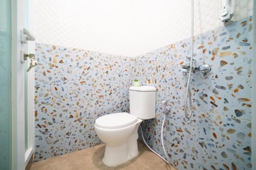 a bathroom with a toilet and a shower at Behomy Boarding Ciledug in Pasarjumahat-Kulon
