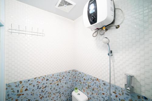 a bathroom with a shower with a toilet in it at Behomy Boarding Ciledug in Pasarjumahat-Kulon