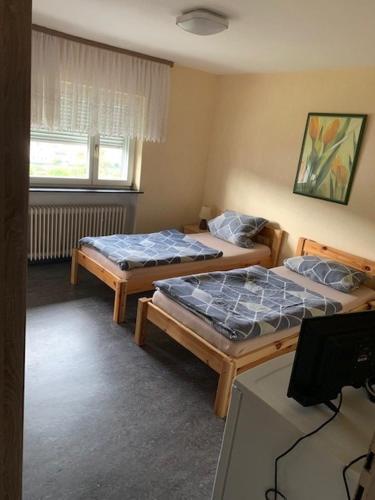 a room with two beds and a window at Monteurpension Haus Monika in Marktheidenfeld
