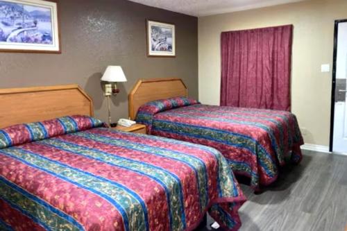 a hotel room with two beds and a window at Golden Inn Dallas by Hotel O in Dallas