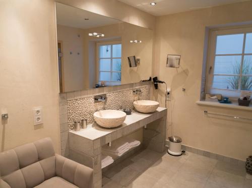 a bathroom with two sinks and a large mirror at Rantum Lodge in Rantum