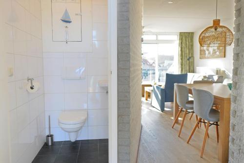 a kitchen and dining room with a table and chairs at Seinpost Appartment in Callantsoog
